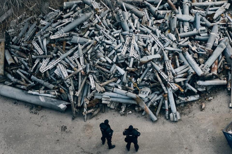 Police officers look at collected fragments of the Russian rockets, including cluster rounds, that hit Kharkiv in Kharkiv, Ukraine on Saturday, Dec. 3, 2022. Russian President Vladimir Putin said in an interview published Sunday that Russia had a “sufficient stockpile” of cluster munitions, warning that Russia “reserves the right to take reciprocal action” if Ukraine uses the controversial weapons.