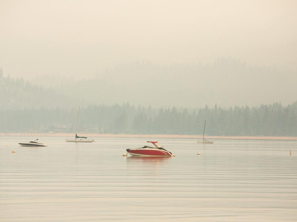 Boats on Lake Tahoe are seen surrounded by smoke due to Caldor Fire