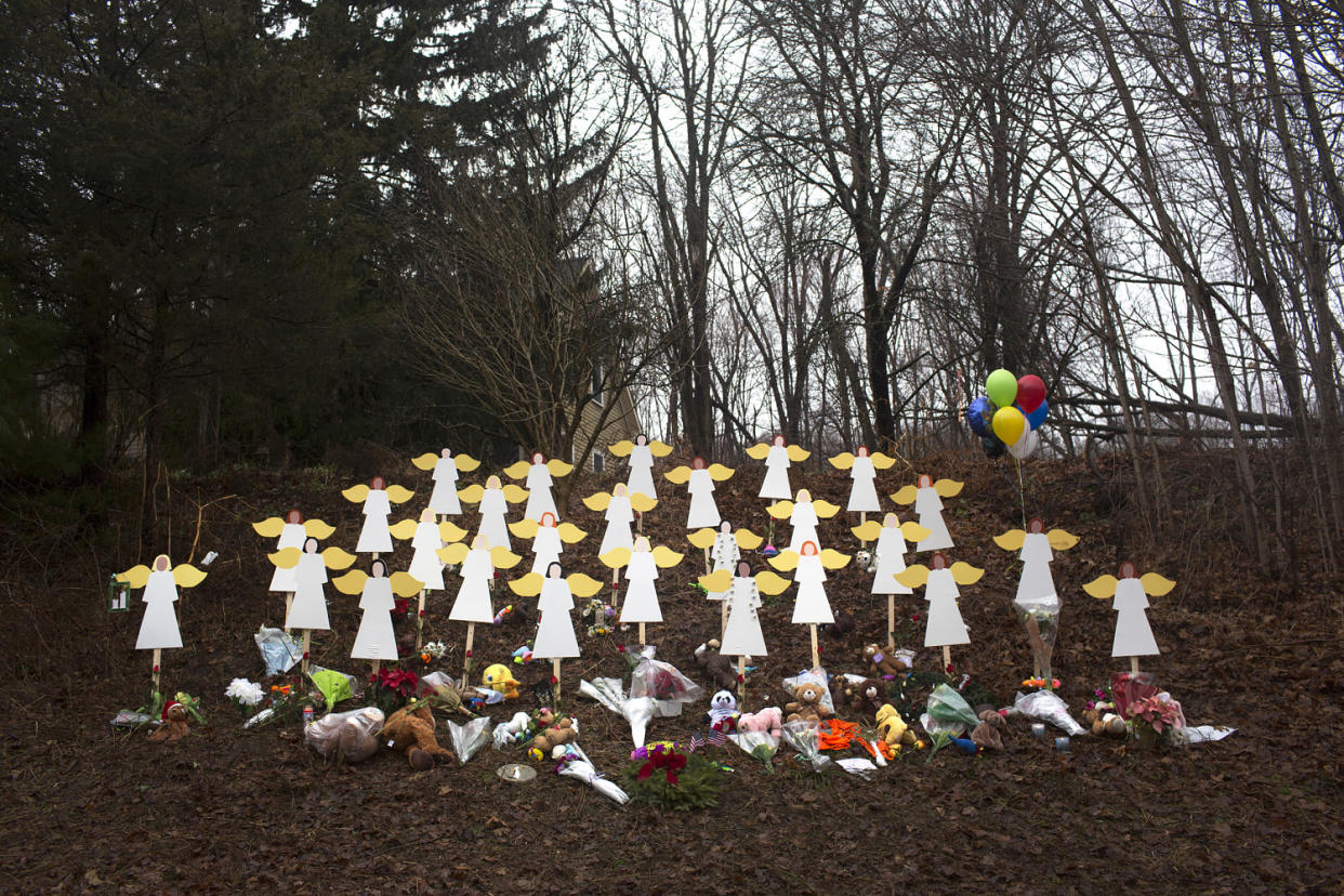 Twenty-seven wooden angel figures along a path surrounded by bouquets of flowers (file Lisa Wiltse/Corbis via Getty Images)