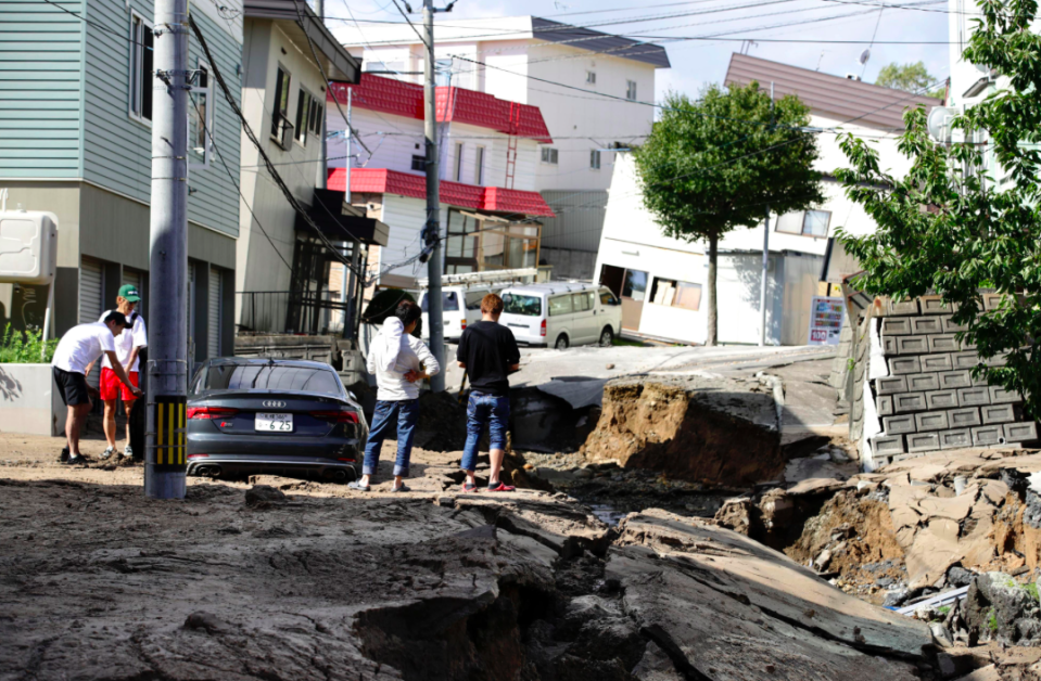 <em>Residents watch a road damaged by the earthquake in Sapporo, Hokkaido (AP)</em>