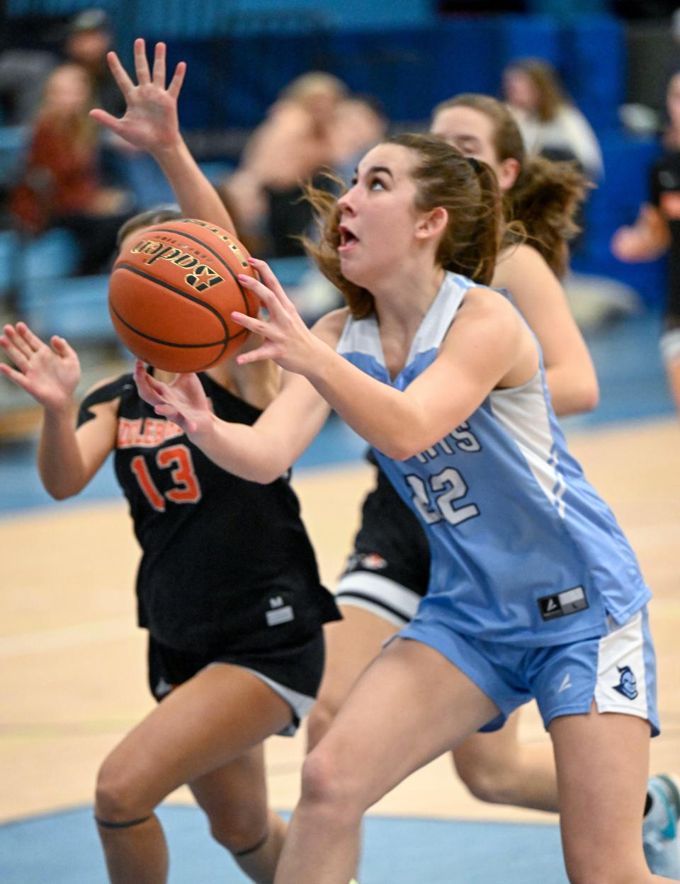 Madi Lawrence of Sandwich goes up for a shot as Olivia Mather of Middleborough closes in.