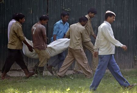 Zoo workers carry the body of a school student who was mauled to death by a white tiger at the National Zoological Park in New Delhi September 23, 2014. REUTERS/Anindito Mukherjee