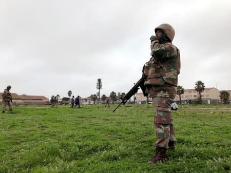 Soldiers patrol as they are deployed to quell gang violence in Manenberg township, Cape Town