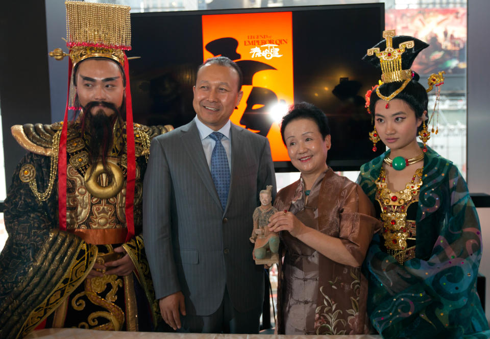 Two costumed members of "The Legend of Emperor Qin" show flank President Wang Yong, second left, of Shaanxi Miracle Achievements Development Co., and the show's producer and director Pan Yang, as they pose for photos in New York's Minskoff Theater, Wednesday, Aug. 28, 2013. Yong and Nederlander Worldwide Entertainment signed an agreement to manage and produce a live show in a planned specially built $65 million, 2000 seat theater adjacent to the Terra Cotta Warriors and Horses exhibition, in Xian, China. (AP Photo/Richard Drew)
