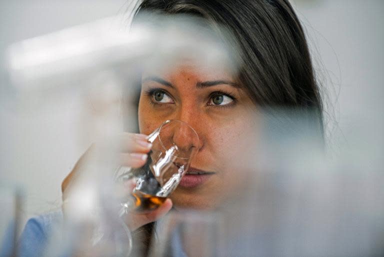 A woman tastes rum during a visit to the Santa Teresa rum factory in La Victoria