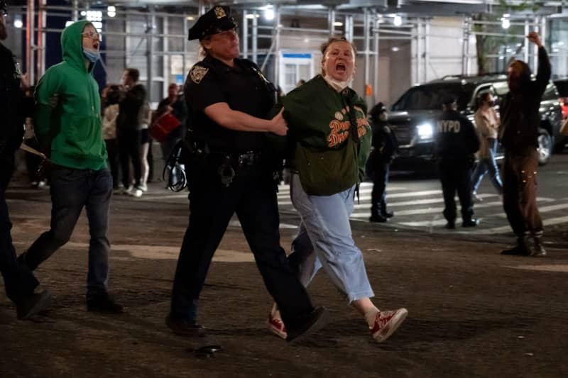 Two protesters shout as officers of the New York City Police Department (NYPD) arrest them. Columbia University calls in the NYPD to "restore safety and order to our community" after Pro-Palestine protesters occupied Hamilton Hall overnight. Syndi Pilar/SOPA Images via ZUMA Press Wire/dpa