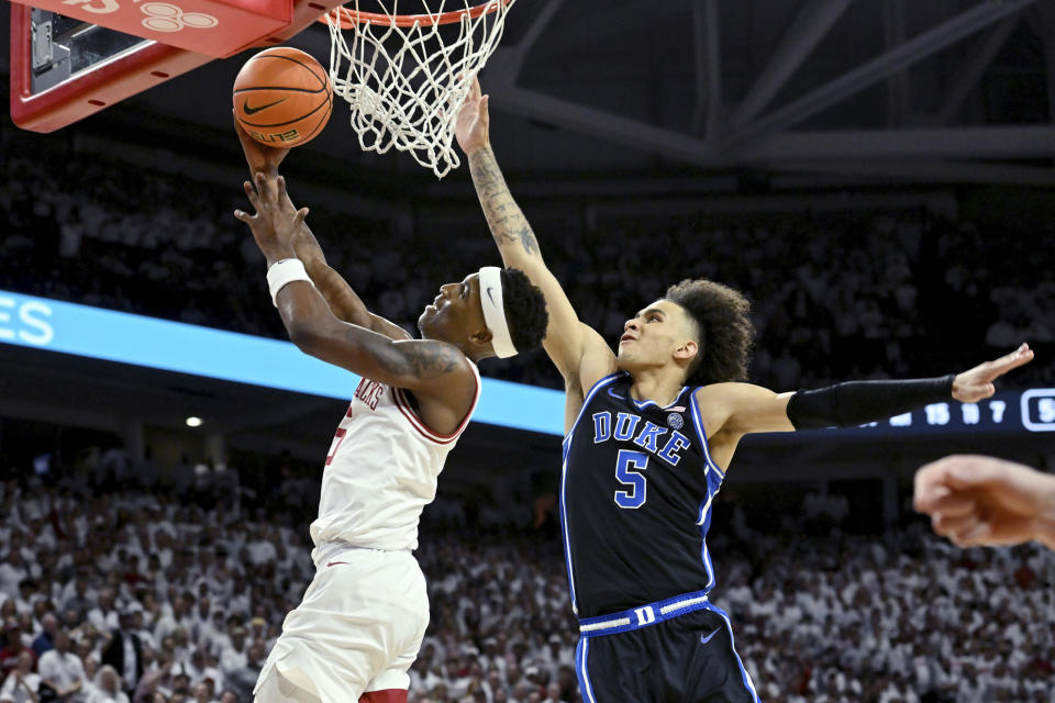 Arkansas guard Layden Blocker (6) drives past Duke guard Tyrese Proctor (5) to score during the second half of an NCAA college basketball game Wednesday, Nov. 29, 2023, in Fayetteville, Ark. (AP Photo/Michael Woods)