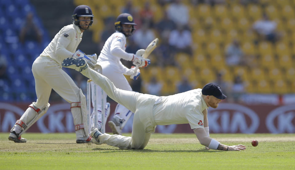 England's Ben Stokes, bottom, dives to stop a ball as wicketkeeper Ben Foakes and Sri Lankan batsman Dhananjaya de Silva watch the ball as they filed during the second day of the second test cricket match between Sri Lanka and England in Pallekele, Sri Lanka, Thursday, Nov. 15, 2018. (AP Photo/Eranga Jayawardena)