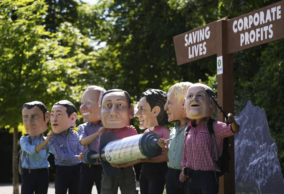 Activists from Oxfam wear giant heads depicting G7 leaders as they pose with a giant syringe during a demonstration in Munich, Germany, Saturday, June 25, 2022. The G7 Summit will take place at Castle Elmau near Garmisch-Partenkirchen from June 26 through June 28, 2022. Leaders depicted from left, French President Emmanuel Macron, Japan's Prime Minister Fumio Kishida, U.S. President Joe Biden, Italy's Prime Minister Mario Draghi, Canada's Prime Minister Justin Trudeau, British Prime Minister Boris Johnson and German Chancellor Olaf Scholz. (AP Photo/Matthias Schrader)