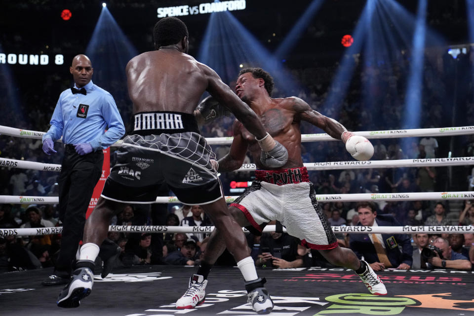 Terence Crawford, left, knocks down Errol Spence Jr. fight during their undisputed welterweight championship boxing match, Saturday, July 29, 2023, in Las Vegas. (AP Photo/John Locher)