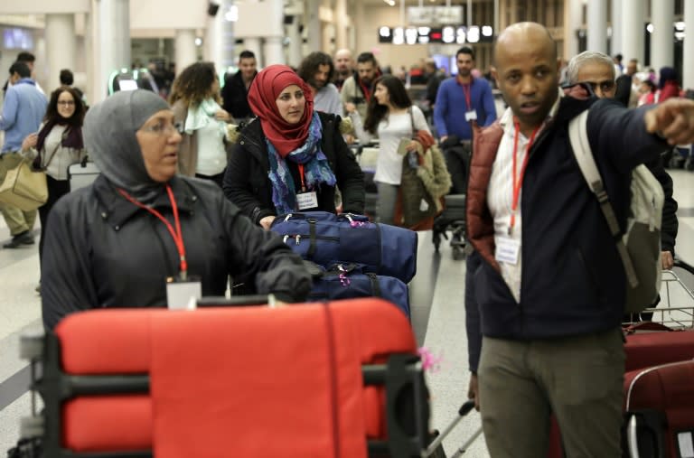 Syrian refugees granted humanitarian visas by the Italian government head to the departures hall in Beirut's International airport for a flight to Rome