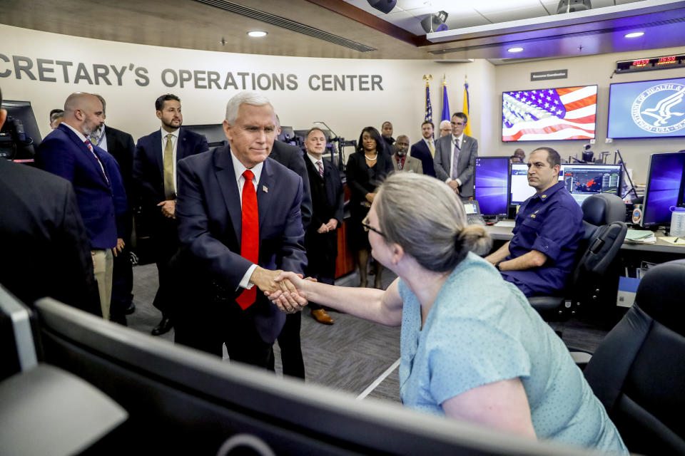 Vice President Mike Pence shakes hands with a worker as he tours the Secretary's Operations Center following a coronavirus task force meeting at the Department of Health and Human Services, Thursday, Feb. 27, 2020, in Washington. (AP Photo/Andrew Harnik)