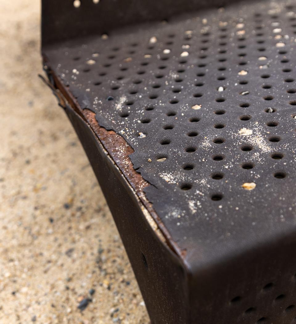 The stairs on the playground are chipping away and becoming rusty.