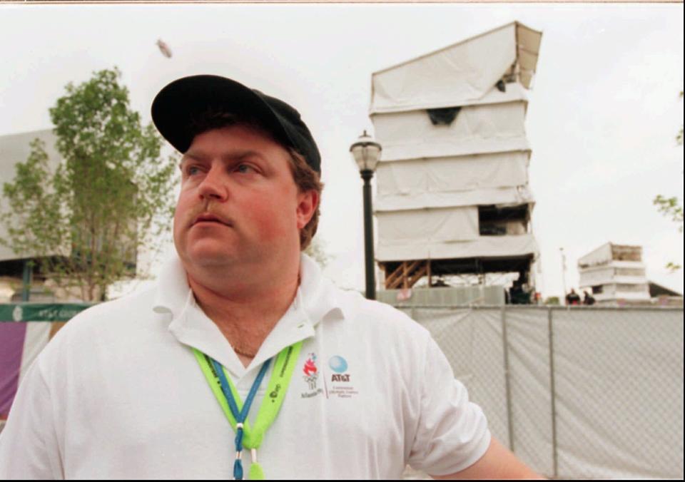 FILE- In this July 28, 1996, file photo, security guard Richard Jewell poses across from the tower where he found a bomb and warned visitors at Centennial Olympic Park in Atlanta. When a bomb exploded in a downtown Atlanta park midway through the 1996 Olympics, it set news reporters and law enforcement on a collision course that upended the life of a security guard, turning him from hero to villain overnight. Now, more than 20 years later, a recent book and upcoming movie explore Jewell's ordeal and the roles played by law enforcement and the media. (William Berry/Atlanta Journal-Constitution via AP, File)