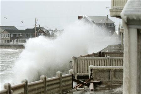 Waves crash into houses on Lighthouse Road during a winter nor'easter snow storm in Scituate