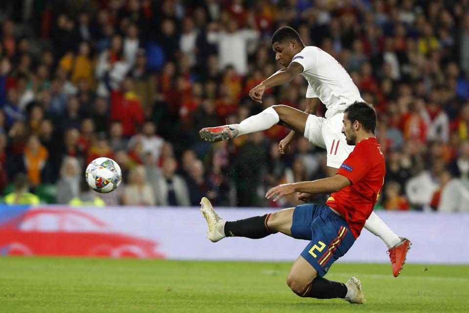 England's Marcus Rashford, background, scores his side's second goal as Spain's Dani Carvajal tries to stop him during the UEFA Nations League soccer match between Spain and England at Benito Villamarin stadium, in Seville, Spain, Monday, Oct. 15, 2018. (AP Photo/Miguel Morenatti)