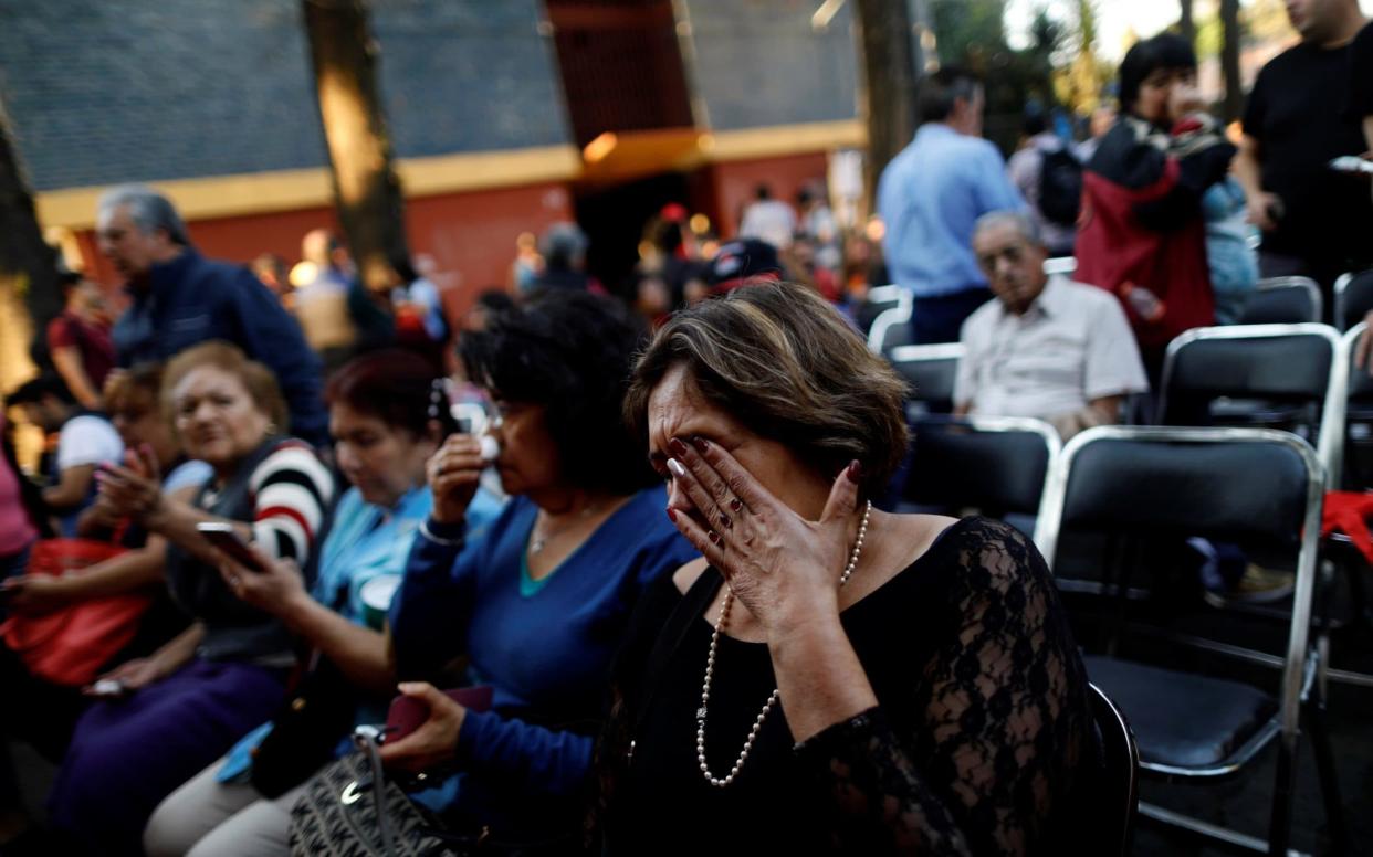 People react after an earthquake shook buildings in Mexico City - REUTERS