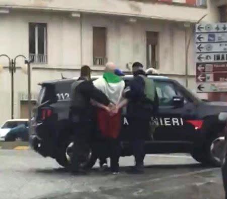 The suspected shooter that opened fire on African migrants, identified as Luca Traini, 28, is seen detained by Italian Carabinieri in Macerata, Italy February 3, 2018. Italian Carabinieri/Handout via REUTERS