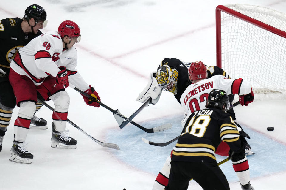 Carolina Hurricanes left wing Teuvo Teravainen, second from left, shoots the puck past Boston Bruins goaltender Jeremy Swayman, top right, for a goal during the second period of an NHL hockey game, Tuesday, April 9, 2024, in Boston. (AP Photo/Charles Krupa)