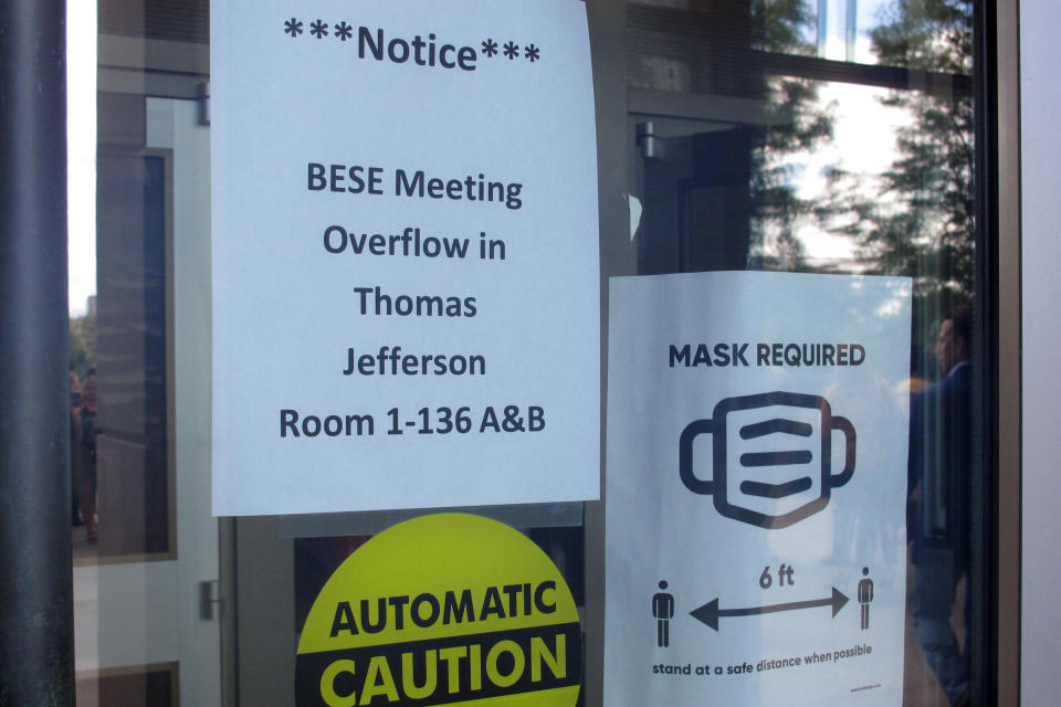 A sign reminds people they must wear masks in the building where the Louisiana Board of Elementary and Secondary Education was holding its meeting on Wednesday, Aug. 18, 2021, in Baton Rouge, La. The board refused to hold a public hearing on whether to challenge Gov. John Bel Edwards' mask mandate because the room was crowded with people who refused to put on face coverings. (AP Photo/Melinda Deslatte)