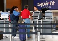 FILE PHOTO: Two passengers talk to a ticketing agent at the Spirit Airlines counter after a Spirit pilots strike was called at Detroit Metropolitan Airport in Romulus