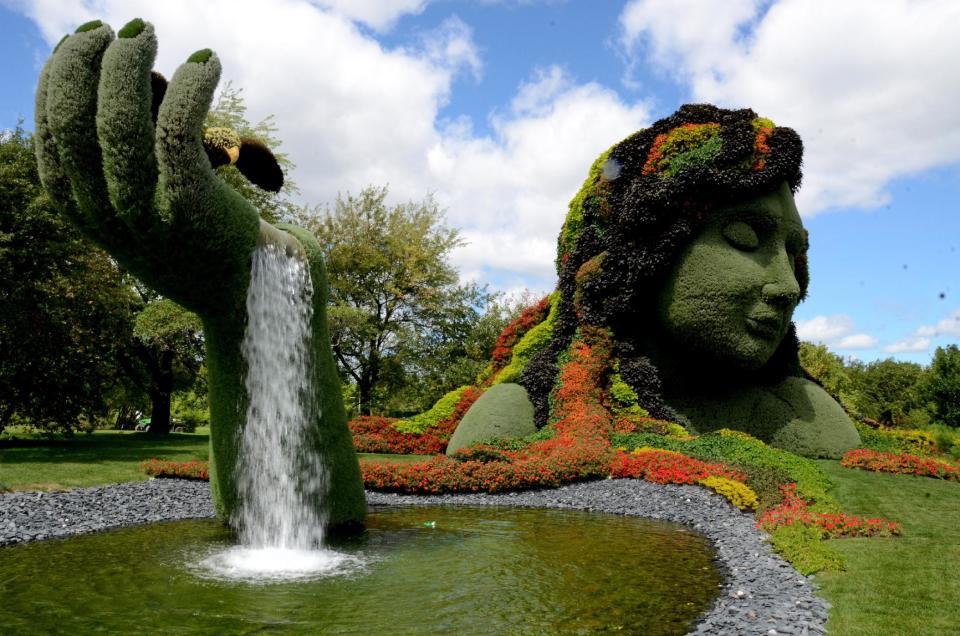 This photo taken Aug. 10, 2013, shows one of the towering plant sculptures that covered the grounds of the Montreal Botanical Gardens in Montreal. Cyclists who want to ride the P'tit Train du Nord rail trail can catch a bicycle shuttle outside Montreal at Saint-Jerome. (AP Photo/R. M. Green)