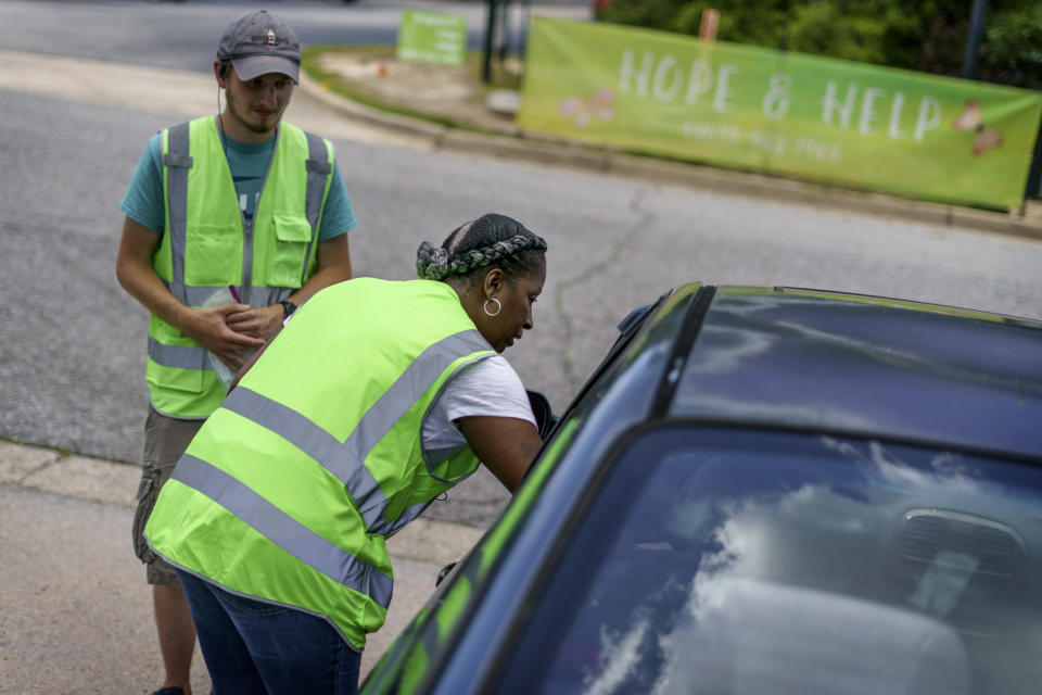 Shonda Johnson, a volunteer for the anti-abortion group, A Moment of Hope, comforts a woman who leaves Planned Parenthood after going through with an abortion, Friday, May 27, 2022, in Columbia, S.C. Thirty-two years ago, Johnson came to this very site for the very same reason, a decision she later came to see as wrong. "When I saw those tears rolling, I knew exactly where she was," she says. (AP Photo/David Goldman)