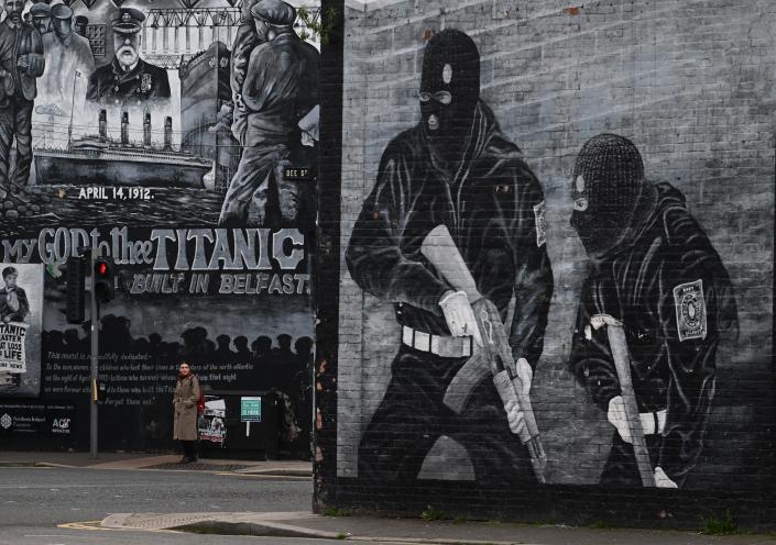 یک ساکن محلی در 4 آوریل 2023 در بلفاست، ایرلند شمالی، از کنار یک نقاشی دیواری شبه نظامی وفادار می گذرد.  توافقنامه جمعه خوب، که در 10 آوریل 1998 امضا شد، به بیشتر خشونت ها در طول چندین دهه درگیری موسوم به The Troubles پایان داد.