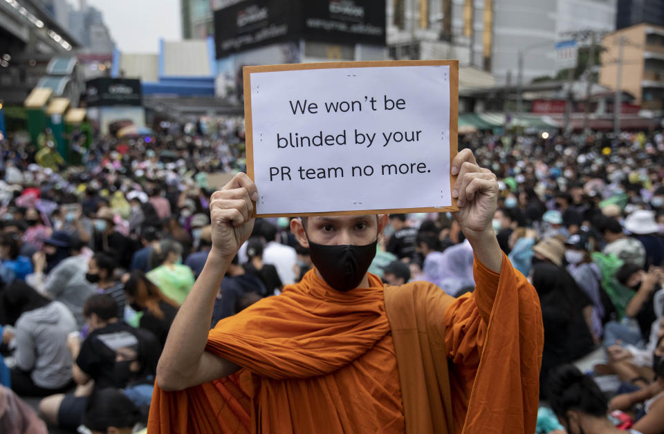 A Buddhist monk, supporter of pro-democracy movement, displays a placard during a protest rally at an intersection in Bangkok, Thailand, Sunday, Oct. 18, 2020. Pro-democracy activists in Thailand launched their fifth straight days of protests on Sunday, scheduling demonstrations not just in the capital but also at several other locations around the country. (AP Photo/Gemunu Amarasinghe)