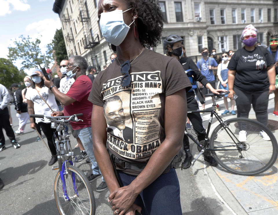 A woman wears a tee-shirt with a photograph of former President Barack Obama as she listens to speakers at a Pray & Protest rally and march, Sunday, June 7, 2020, in the Bedford-Stuyvesant neighborhood of the Brooklyn borough of New York. The protests have been a reaction to the death on May 29 of George Floyd, who died while in the custody of four Minneapolis police officers on Memorial Day. (AP Photo/Kathy Willens)