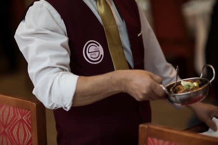 A waiter serves vegan dishes at the City Spice curry house restaurant on Brick Lane in London, Britain January 7, 2019. Picture taken January 7, 2019. REUTERS/Simon Dawson