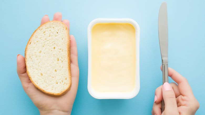 Bread and knife over magarine tub