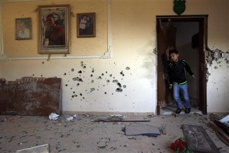 A boy walks out of a door in the house where Palestinian Hamas militant Hamza Abu Alhija was killed in the West Bank refugee camp of Jenin March 22, 2014. REUTERS/Mohamad Torokman