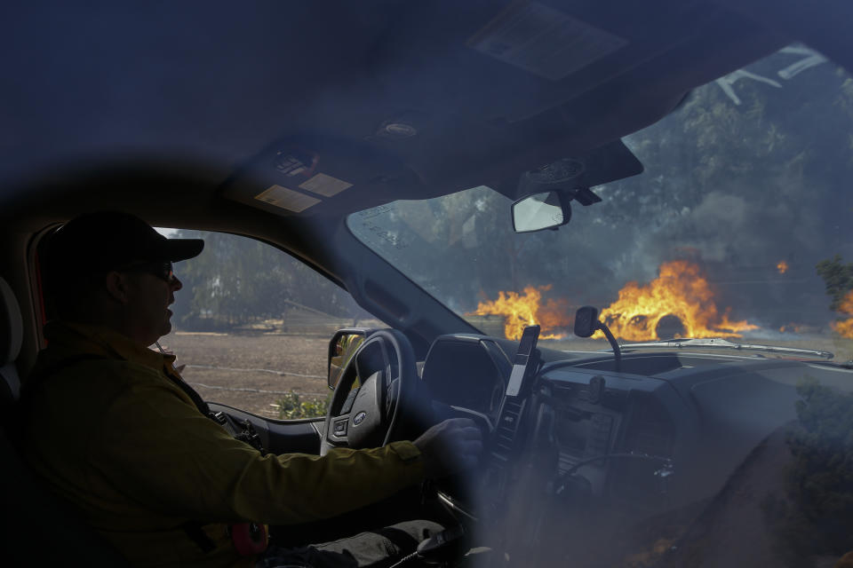 Firefighter Kris McDonald keeps watch on the wildfire burning near a ranch in Simi Valley, Calif., Wednesday, Oct. 30, 2019. (AP Photo/Ringo H.W. Chiu)