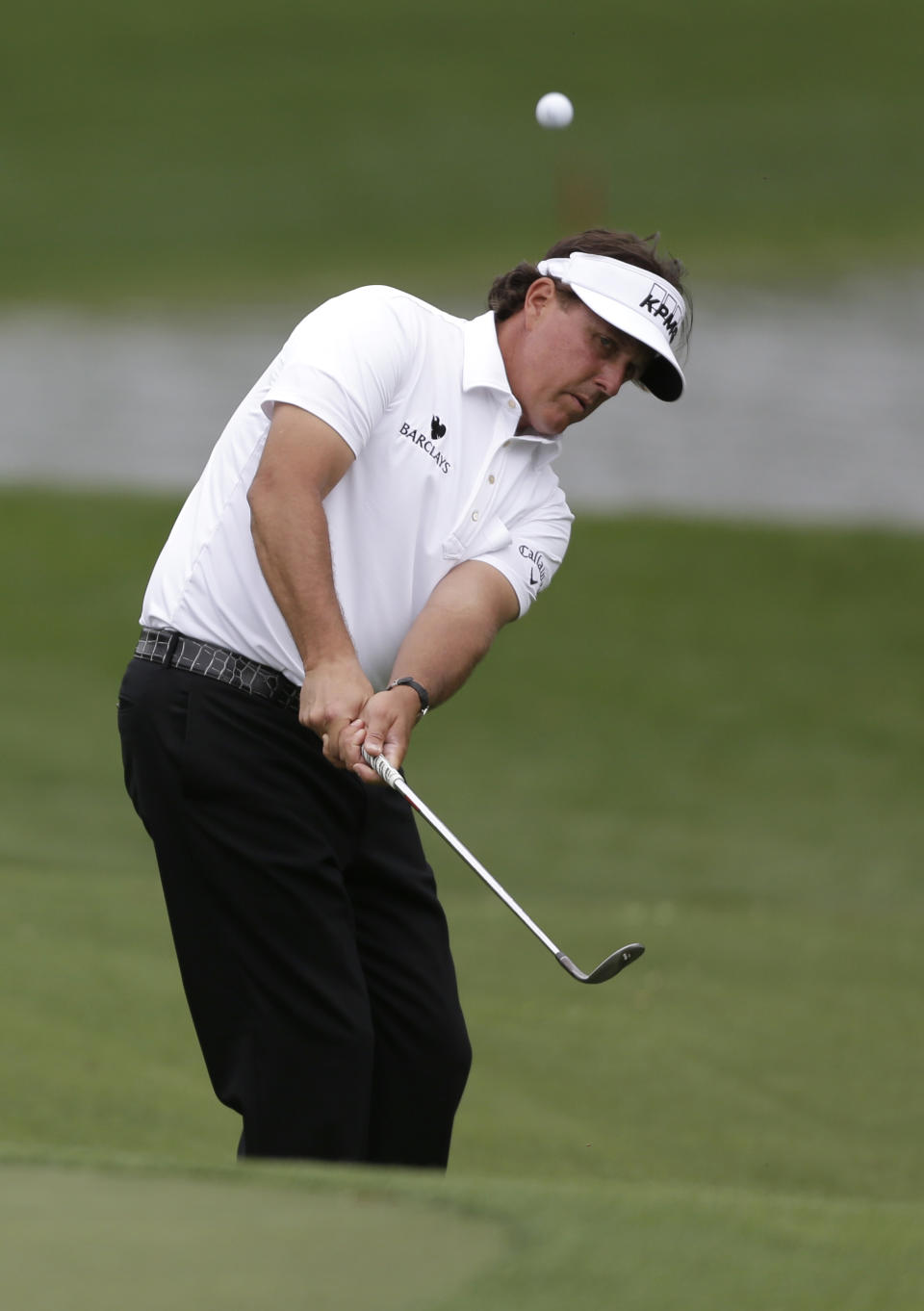 Phil Mickelson chips to the 16th green during the first round of the Wells Fargo Championship golf tournament in Charlotte, N.C., Thursday, May 1, 2014. (AP Photo/Bob Leverone)