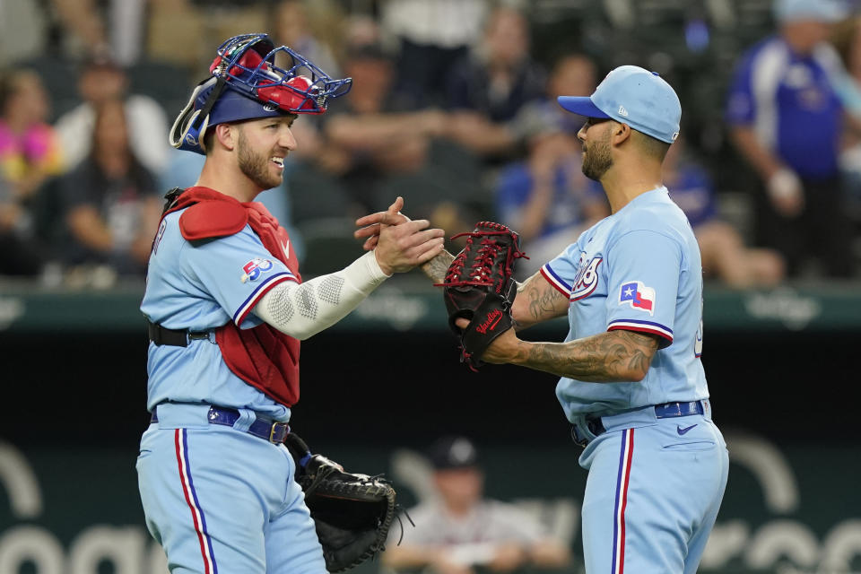 Texas Rangers catcher Mitch Garver, left, congratulates pitcher Matt Bush (51) after the final out of a baseball ball game against the Atlanta Braves in Arlington, Texas, Sunday, May 1, 2022. (AP Photo/LM Otero)