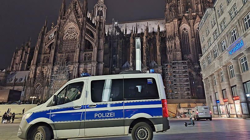 A police vehicle is parked in front of the cathedral in Cologne, Germany, Saturday, Dec. 23, 2023.