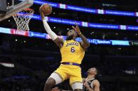 Los Angeles Lakers forward LeBron James, left, shoots as San Antonio Spurs forward Keldon Johnson defends during the first half of an NBA basketball game Wednesday, Jan. 25, 2023, in Los Angeles. (AP Photo/Mark J. Terrill)