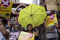 A pro-democracy protester holds a yellow umbrella, the symbol of the Occupy Central movement, during a march to demand lawmakers reject a Beijing-vetted electoral reform package for the city's first direct chief executive election in Hong Kong, China June 14, 2015. REUTERS/Tyrone Siu