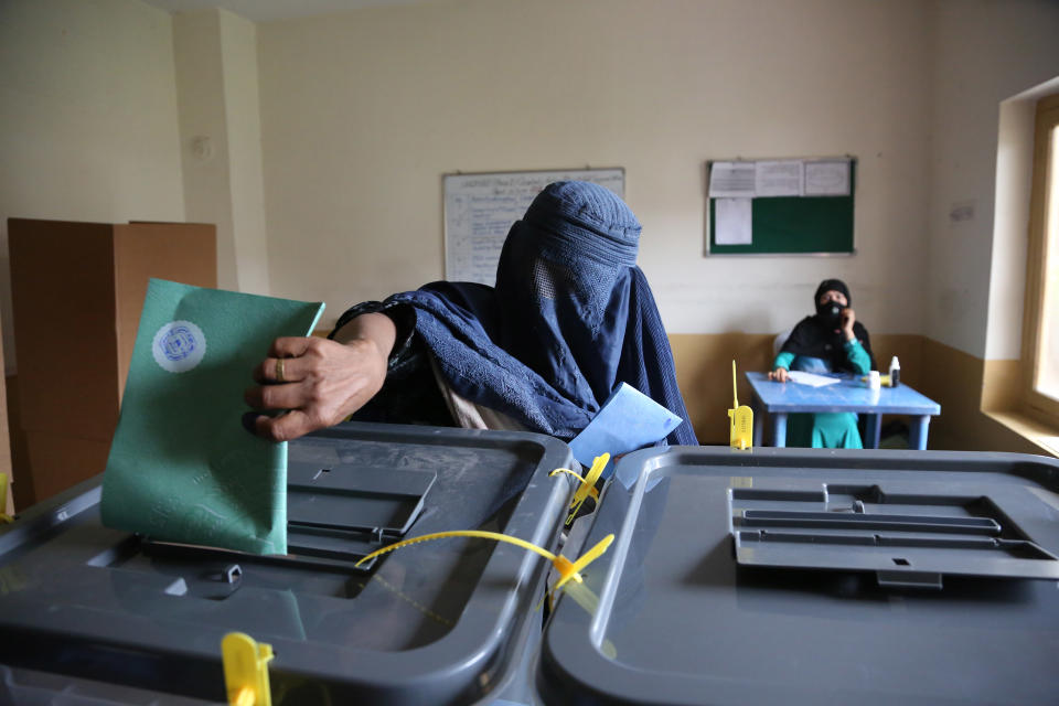 An Afghan woman casts her vote at a polling station in Jalalabad east of Kabul, Afghanistan, Saturday, April 5, 2014. Afghan voters lined up for blocks at polling stations nationwide on Saturday, defying a threat of violence by the Taliban to cast ballots in what promises to be the nation's first democratic transfer of power. (AP Photo/Rahmat Gul)