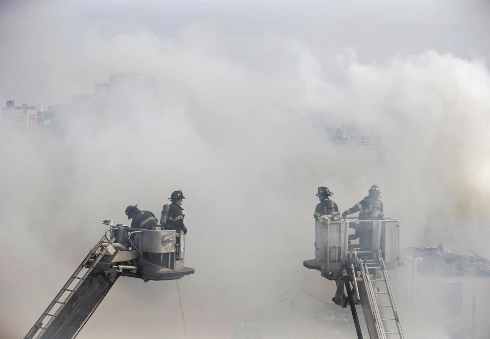 Firefighters respond to an explosion that leveled two apartment buildings in the East Harlem neighborhood of New York, Wednesday, March 12, 2014. Con Edison spokesman Bob McGee says a resident from a building adjacent to the two that collapsed reported that he smelled gas inside his apartment, but thought the odor could be coming from outside. (AP Photo/John Minchillo)