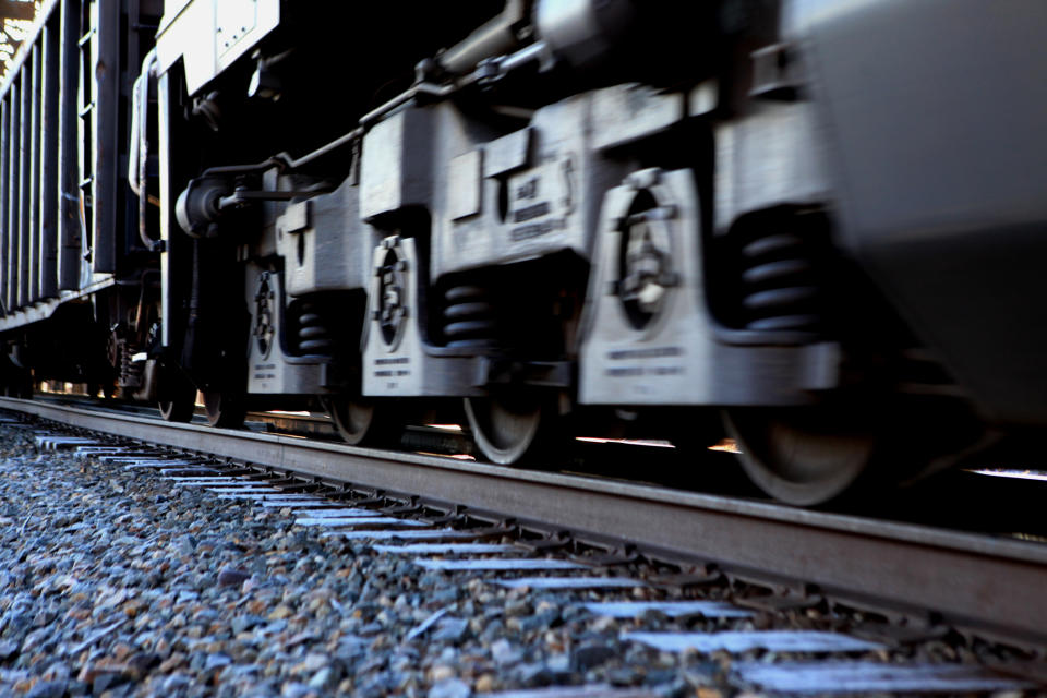 Close-up of a locomotive's wheels as it moves along a rail track.