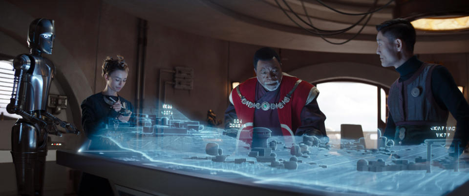 (L-R): A design droid, Civic Engineer (Maya Ramsey), Greef Karga (Carl Weathers), and Civic Engineer (London Kim) in 'The Mandalorian.'