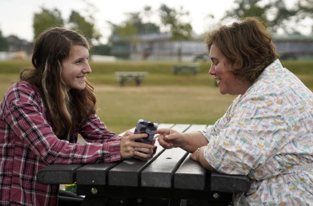 Leyna McQuillin, left, looks at her results on her phone with her mother Michelle McQuillin at Peter Symonds College, Winchester, Hampshire 