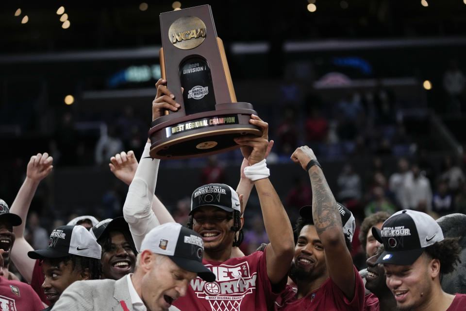 Alabama players hold the winner's trophy after a win over Clemson in an Elite 8 college basketball game in the NCAA tournament Saturday, March 30, 2024, in Los Angeles. (AP Photo/Ashley Landis)