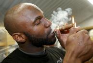 Saskatchewan Roughriders quarterback Darian Durant lights up a cigar in the locker room after his team defeated the Hamilton Tiger Cats to win the CFL's 101st Grey Cup championship football game in Regina, Saskatchewan November 24, 2013. REUTERS/Todd Korol (CANADA - Tags: SPORT FOOTBALL)