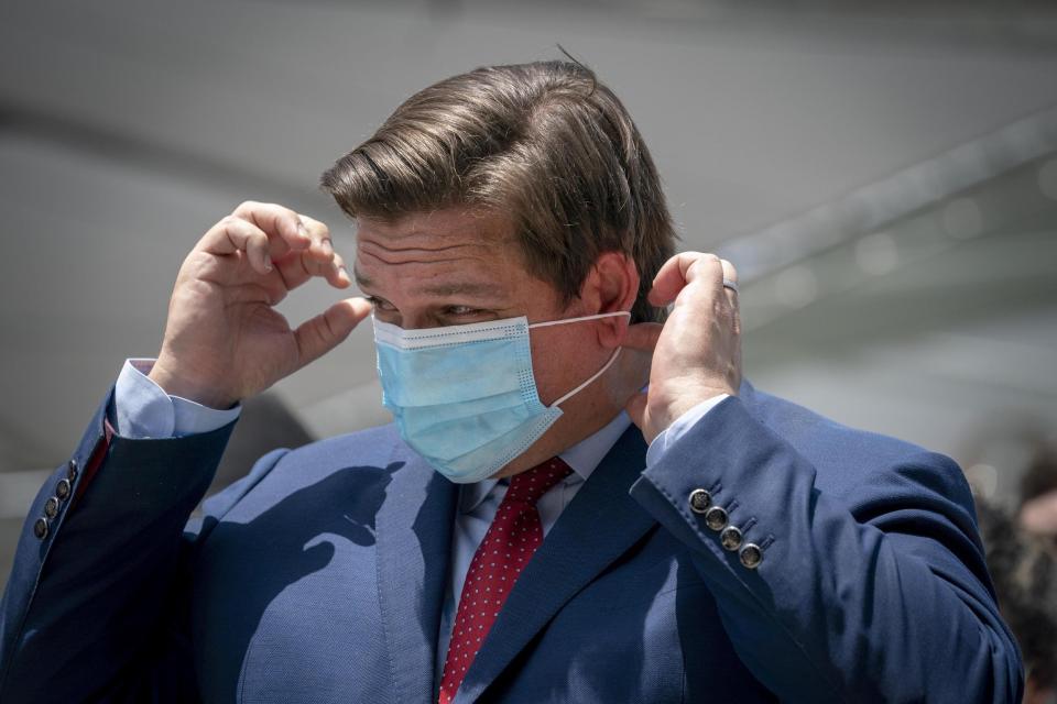 Gov. Ron DeSantis puts his mask on after speaking at the Loggerhead Marinelife Center in Juno Beach in 2020.