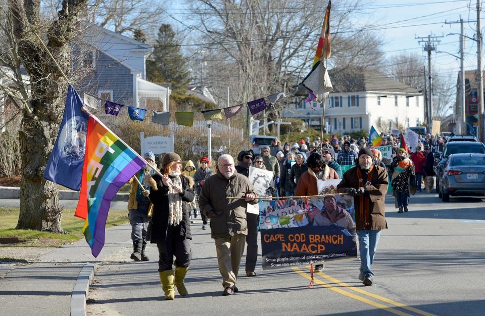 Tracy Plaut, of Wellfleet, Danny Williams, of Wellfleet, and James Kershner, of Cummaquid, left to right, lead the walkers down Main Street in Wellfleet Monday afternoon for the 21st annual ArtPeaceMakers "WalKING" celebration. To see more photos, go to www.capecodtimes.com.