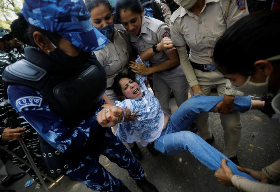 Police officers detain a supporter of India’s main opposition Congress Party on 27 March (Reuters)