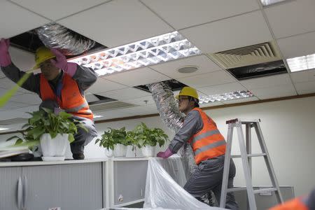 Workers install a new clean air system in J.D. Power's office in Shanghai, December 20, 2015. REUTERS/Aly Song